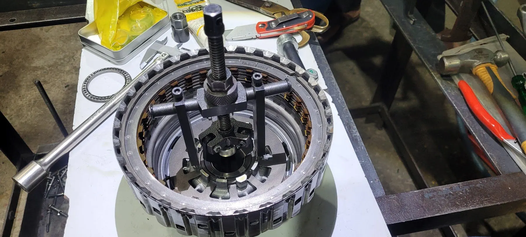 Clutch pack being inspected in a spring compressor on the workbench