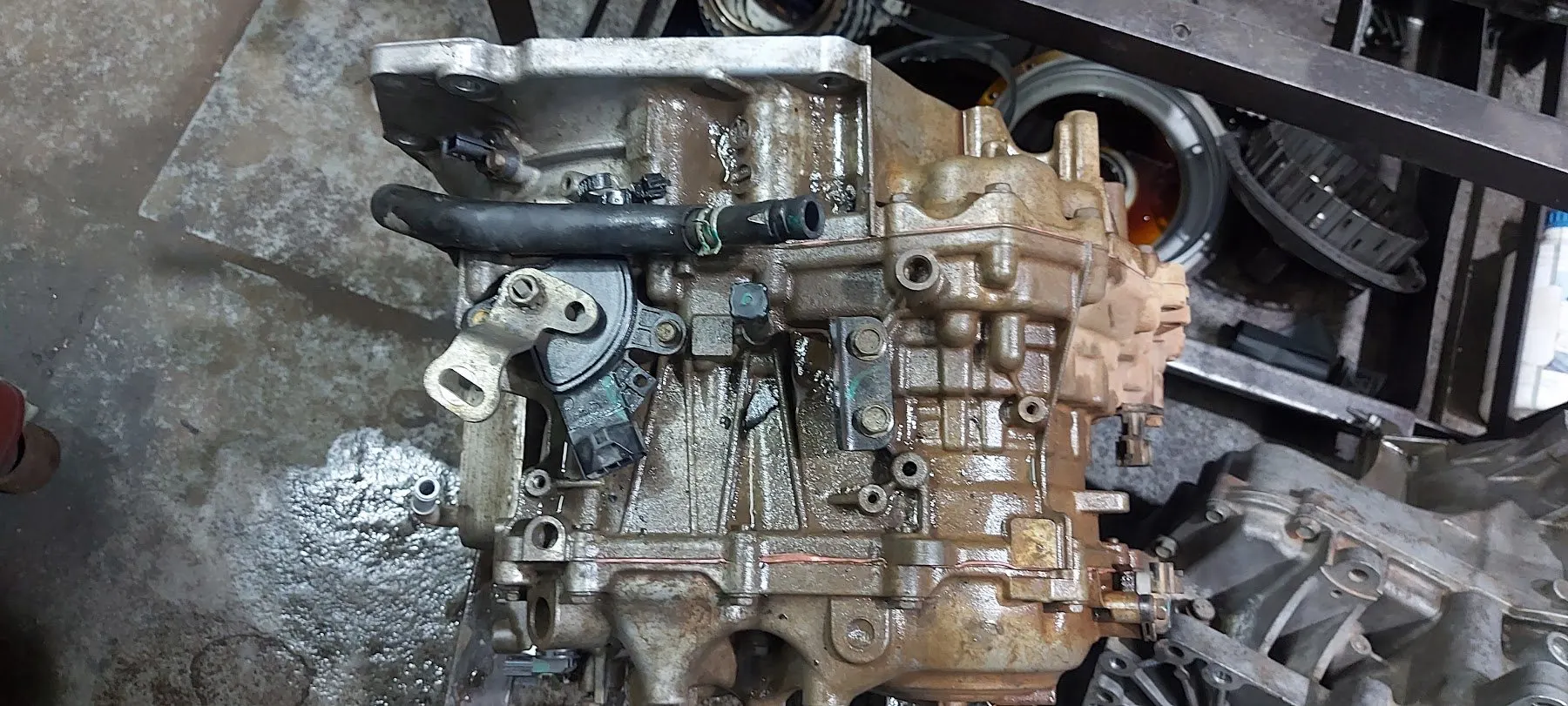 Gearbox and transfer housing covered in old oil residue before repair
