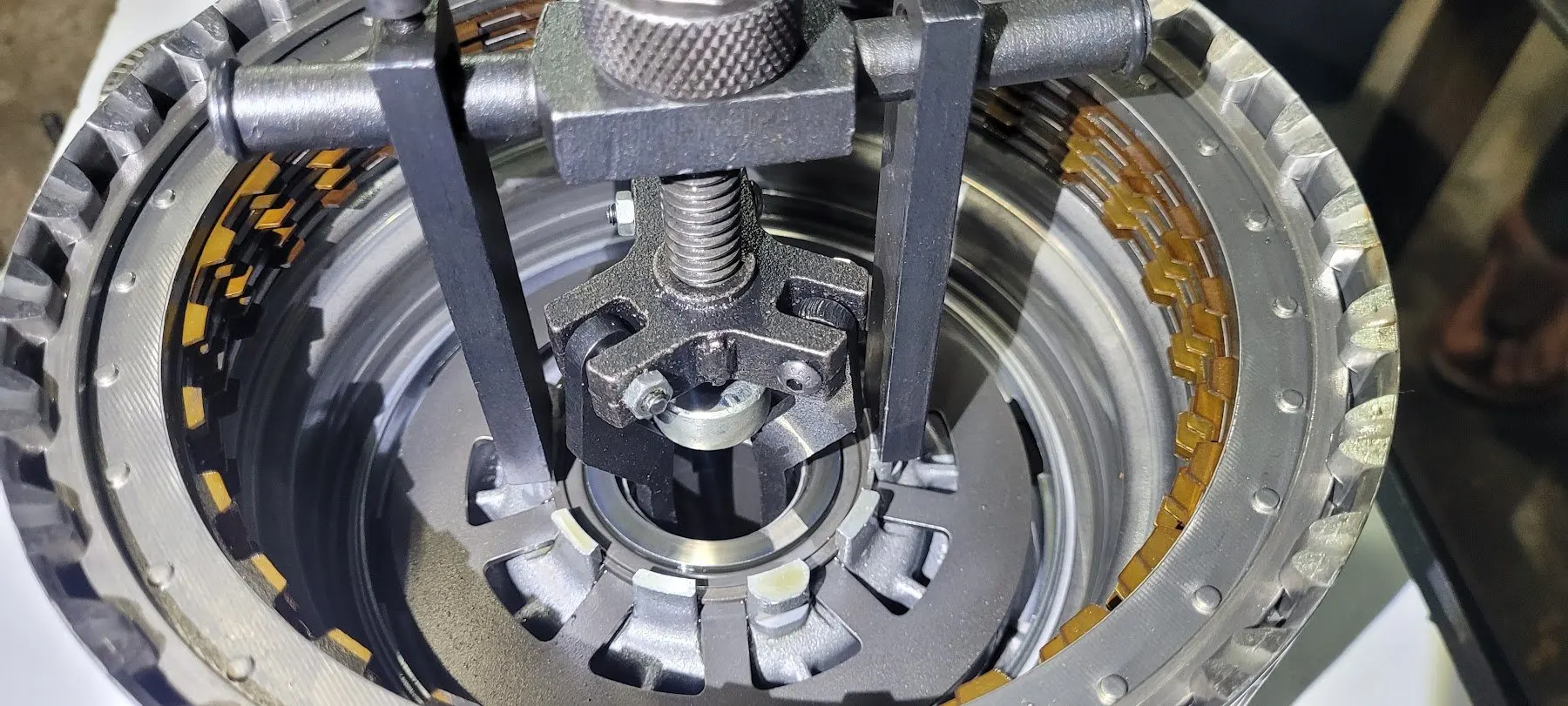 Clutch drum from an automatic gearbox held in a spring compressor during an overhaul